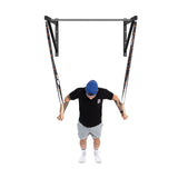 Wearing a black shirt, gray shorts, and a blue cap, a person uses gymnastic rings on the Bells of Steel Adjustable Wall or Ceiling Mounted Pull Up Bar. They are positioned forward as if doing a ring push-up against a plain white background.