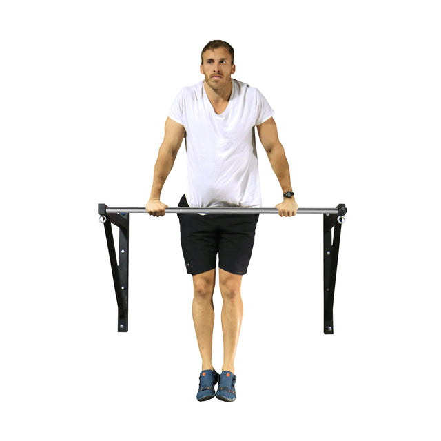 A man in a white t-shirt and black shorts does a dip on a Bells of Steel Adjustable Wall or Ceiling Mounted Pull-Up Bar, maintaining focus with straight arms and legs close together.