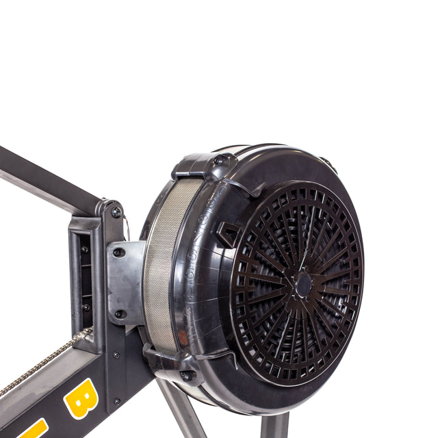 Close-up of the Blitz Air Rower flywheel by Bells of Steel against a white background. The fan-like design connects to a sturdy metal frame showcasing parts of the chain mechanism and yellow lettering, ideal for low-impact cardio workouts.