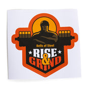 A durable Bells of Steel sticker featuring a graphic design of a muscular figure with a barbell, "Bells of Steel" above, "RISE & GRIND" below in bold colors, set on an orange sunburst background. Quality adhesive ensures long-lasting display.