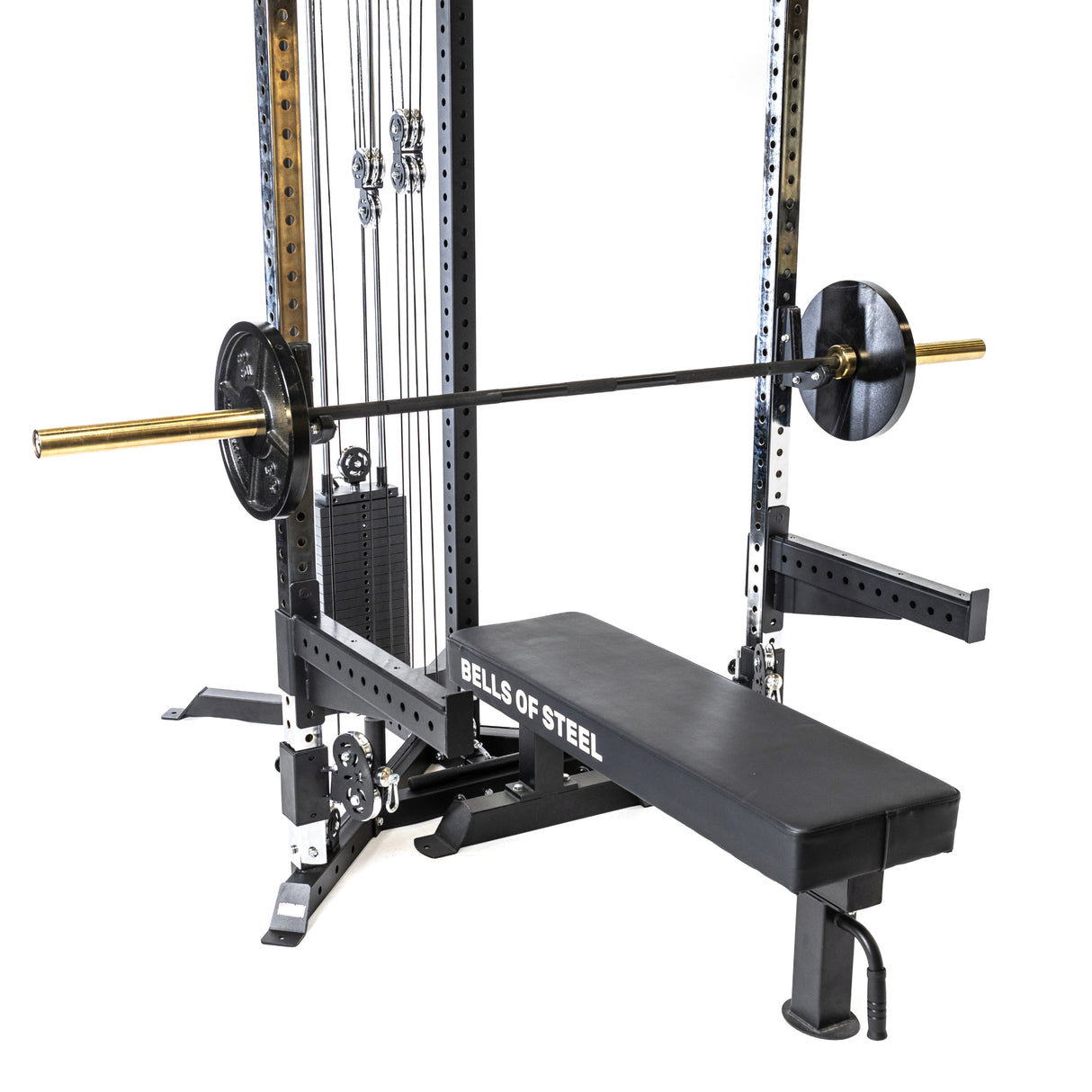 The Bells of Steel All-in-One Trainer includes a weightlifting bench with a barbell on the rack, featuring a pulley system with weight stacks and a padded bench, perfect for any comprehensive gym routine.