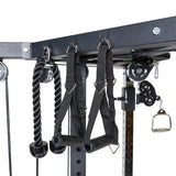 Close-up of Bells of Steel's All-in-One Trainer, a functional trainer featuring a cable machine with rope and strap handles, pulleys, and metal hooks for resistance training and comprehensive workout options.