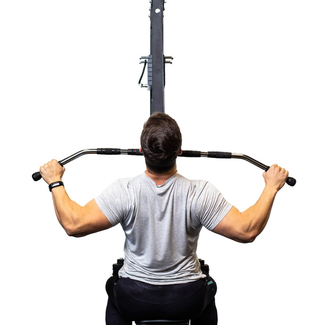 A person in a gray t-shirt uses the Bells of Steel Lat Pulldown Bar with rubberized grips, enhancing hold while working back muscles. The bar's rotating connection aids fluid motion, all highlighted against a white background.