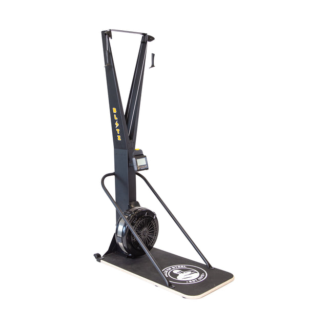 The Bells of Steel Blitz Ski Trainer is a black machine with a fan flywheel, monitor, and dual handles on a platform with a white logo—ideal for full-body workouts or simulating cross-country skiing indoors.