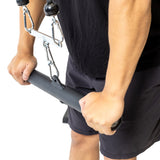 A person grips the Bells of Steel Fat Bar - Straight Handle Bar attached to a cable machine, preparing for a strength training exercise. The image highlights their hands and grip on the thick, straight bar.