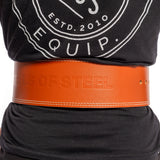 A person wearing a black shirt with a circular logo dons an orange 10mm Leather Weightlifting Belt by Bells of Steel USA, featuring "BELLS OF STEEL" embossing and a single-prong design for secure support.