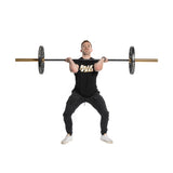 A person doing a front squat with a barbell and Technique Plates - 5 Lbs (Pair), wearing a black "Bells of Steel" shirt and black pants against a white backdrop, is centrally featured in the image.