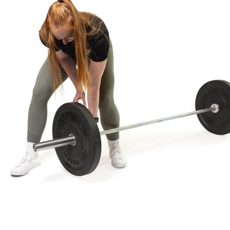 Female athlete loading Crumb Bumper Plates on the  barbell