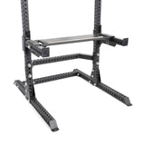 A close-up of the Bells of Steel Utility Seat for Hydra/Manticore attached to a black 3"x3" rack frame with a flat bench, showing multiple holes for adjustable weightlifting and strength training settings.