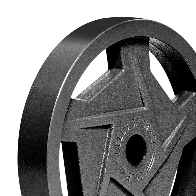 Close-up of a Bells of Steel Black Mighty Grip Olympic Weight Plate with a star-shaped design and precision grip handles. "BELLS OF STEEL" is embossed around the central hole, while shadows highlight its ergonomic design and texture.