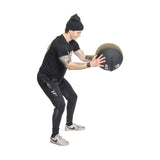 Male athlete holding Triple Stitched Medicine Ball while looking at it