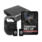 The Wildman Turkish Get Up Adjustable Kettlebell Bundle by Bells of Steel USA, complete with wrist wraps and a "Turkish Get-Up Master Class Program" on a tablet, alongside branded exercise mats, enhances your functional strength-building routine.