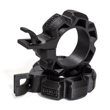 Two black, rugged Barbell Zip Clips - Half Standard (Pair) from Bells of Steel, circular with ridged edges and integrated clips, are stacked together on a white background, resembling standard barbell clips.