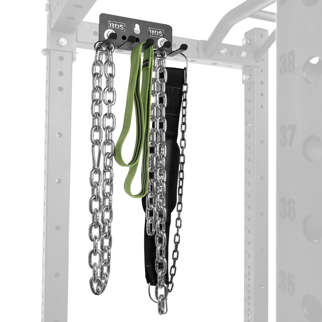 The Bells of Steel Accessory Holder (Wall or Rack Mounted) organizes lifting chains, a green resistance band, and a black weightlifting belt, keeping your gym accessories neat and accessible on its gray, numbered rack.