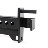 Close-up of the Bells of Steel Spotter Arms Rack Attachment, a black metal bracket with a handle and several holes for adjusting or holding equipment. Its rectangular base and cylindrical grip have UHMW lining for durability, ensuring robust support independently or with attachments.