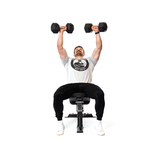 A person sits on the Dumbbell Bench Combo, lifting two dumbbells overhead. They're dressed in a gray T-shirt, black pants, and white shoes against a plain white background.