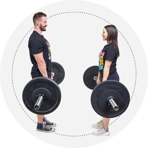 A man and woman face each other holding the Partner Bar Bumper Set. They wear black T-shirts and athletic shoes, set against a white background with a dotted circular border.