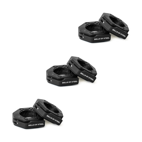 Three pairs of black hexagonal "Bells of Steel" weight plates are stacked diagonally on a white background, ideal for use with Bells of Steel Magnetic Clamp Collars to ensure secure and safe lifting.