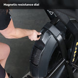 A person adjusts the resistance dial on a Bells of Steel Blitz Max Air Bike, commercial fitness equipment with a large fan and sturdy frame.