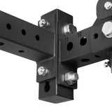 Close-up of Bells of Steel USA Rack Junctions - 3" x 3": a black metal connector with multiple bolts and holes, joining two rectangular steel beams—ideal for building a heavy-duty, customizable home gym rack.
