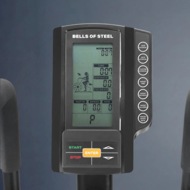 Close-up of the Bells of Steel Blitz Air Bike's digital console showing time, distance, calories, speed, RPM, and other stats, with labeled buttons on the right and START/STOP/ENTER controls at the bottom.