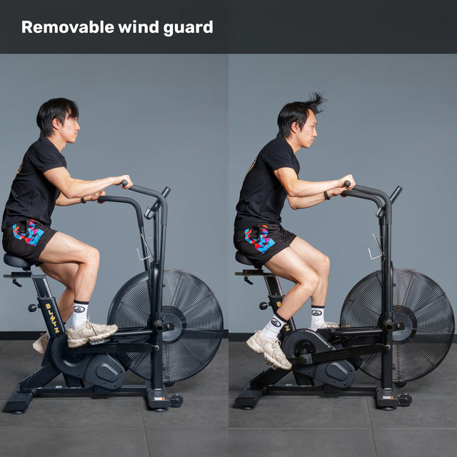 Side-by-side images show a person using the Bells of Steel Blitz Air Bike: left with wind guard, right with hair blown upward without it. Text above reads "Removable Wind Guard.