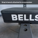 Close-up of a padded gym bench labeled "Bells of Steel USA," attached to the Crossmember For Converter Bench - 43" with adjustment holes; text above reads "Drop in bench attached to crossmember," ideal for two-post rack setup.