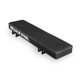 The Bells of Steel USA Converter Bench - Flat Drop In is a black rectangular modular bench with "BELLS OF STEEL" in white on the side, a padded top, sturdy metal legs, and is built to IPF competition height for intense training.