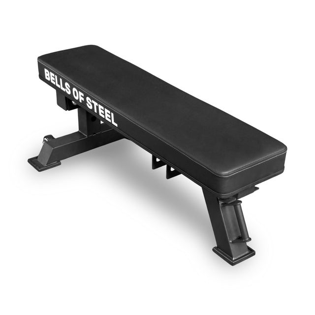 The Bells of Steel USA Converter Bench – Flat Drop In is a black IPF competition workout bench with "BELLS OF STEEL" in white on the side and a sturdy metal frame, shown angled on a white background.