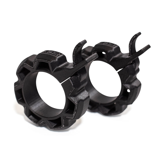 A pair of Bells of Steel Barbell Zip Clips - Half Standard, featuring a black 3D-printed gear-like design with locking levers, displayed on a white background.