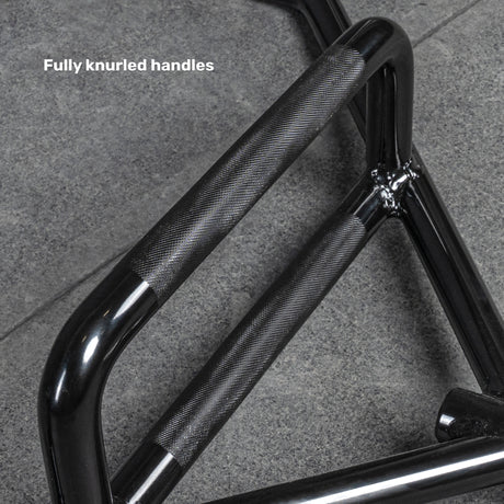 Close-up of the Bells of Steel Open Trap Bar / Hex Bar with two black, fully knurled handles on a grey stone floor. “Fully knurled handles” is displayed in the top left corner.