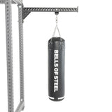 A black heavy bag from Bells of Steel USA hangs from a chain attached to a sturdy metal support frame, making this Heavy Bag Set an ideal addition to any power rack or gym setup, displayed against a white background.