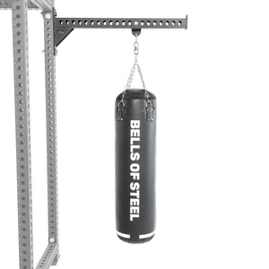 A black heavy bag from Bells of Steel USA hangs from a chain attached to a sturdy metal support frame, making this Heavy Bag Set an ideal addition to any power rack or gym setup, displayed against a white background.