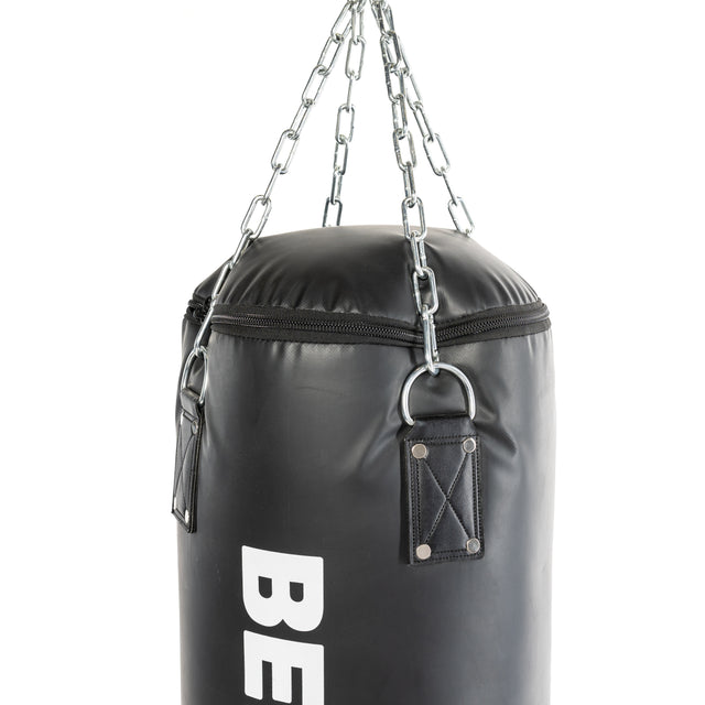 Close-up of a Bells of Steel Heavy Bag Set, black and hanging by metal chains, ideal for a power rack or utility arm. The top is secured with sturdy straps, featuring a bold white logo on the leather or synthetic material.