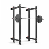 The Roc Foldable 4 Post Cage Builder by Bells of Steel is a sleek, black power rack with a barbell and weight plates. This foldable rack features ⅝" holes for adjustable height settings and safety pins, making it ideal for weightlifting with modular components.