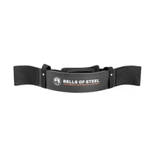The Bells of Steel Arm Blaster is a black, padded arm support with a neck strap and the brand’s logo—ideal for isolating biceps during curls or providing extra support for tricep pushdowns.