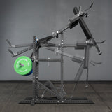 The Bells of Steel USA Pandemonium Squat – a 3-in-1 Pendulum Squat, Calf Press, and Viking Press Machine – is shown in black with padded supports, a green weight plate, and set against a gray wall and floor.