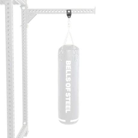 The Bells of Steel Utility Shackle Rack Attachment is an essential addition to any home gym, featuring a gray boxing bag suspended by chains from a sturdy metal support. Its versatile design enhances training flexibility with ease.