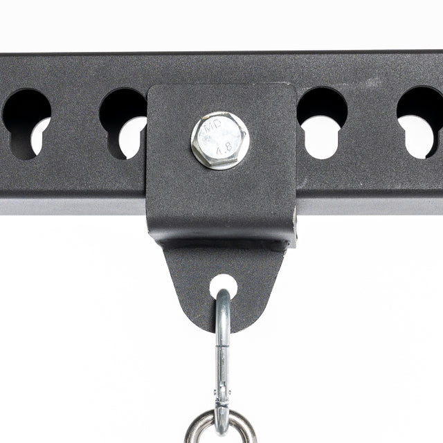 Close-up of a Bells of Steel Utility Shackle Rack Attachment, featuring a black metallic bracket with a bolt and holes along its length. A utility shackle hangs from the bracket against a plain white background, ideal for showcasing this essential home gym accessory.