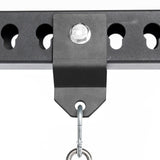 Close-up of the Bells of Steel Utility Shackle Rack Attachment in black metal, securely fastened to a perforated metal bar with a large bolt, featuring a metal hook hanging from the bracket—perfect for mounting gym equipment or organizing home gym accessories.