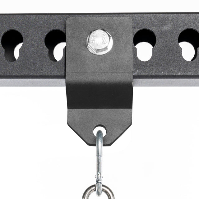 Close-up of the Bells of Steel Utility Shackle Rack Attachment in black metal, securely fastened to a perforated metal bar with a large bolt, featuring a metal hook hanging from the bracket—perfect for mounting gym equipment or organizing home gym accessories.