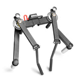 A black metal Bells of Steel Shoulder Boulder/Chest Fly Attachment with adjustable legs and silver round feet, designed for rack mounting, is shown against a white background.