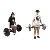 Two people demonstrate the Bells of Steel USA Specialty Bar Bundle: a woman in black and pink prepares to squat with a trap/hex bar, while a man in light clothes stands holding the same bar at his sides.