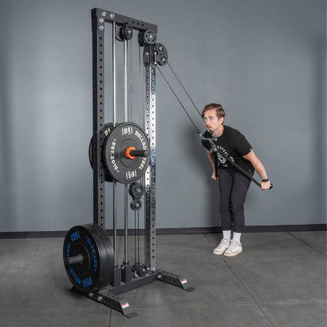 A person uses the Bells of Steel Extra Long Tricep Rope Extension (137cm) for tricep pushdowns on a cable machine in a gym, with a gray wall and floor in the background.
