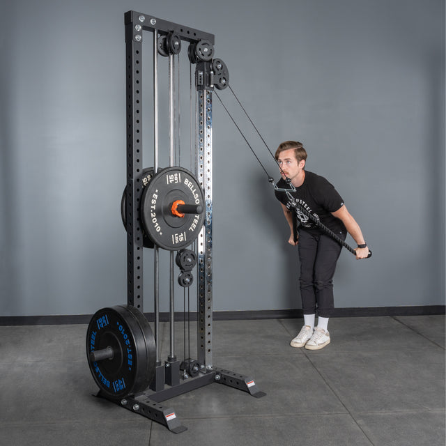A person uses the Bells of Steel Extra Long Tricep Rope Extension (137cm) for tricep pushdowns on a cable machine in a gym, with a gray wall and floor in the background.